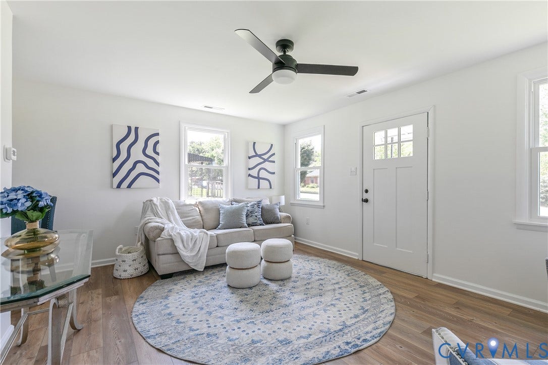 1809 Sussex Street, Whitcomb, Richmond, VA 23223 Wood-finish flooring, multi-pane exterior door with glass detailing, three-blade ceiling fan with integrated light, and crisp white wall finishes