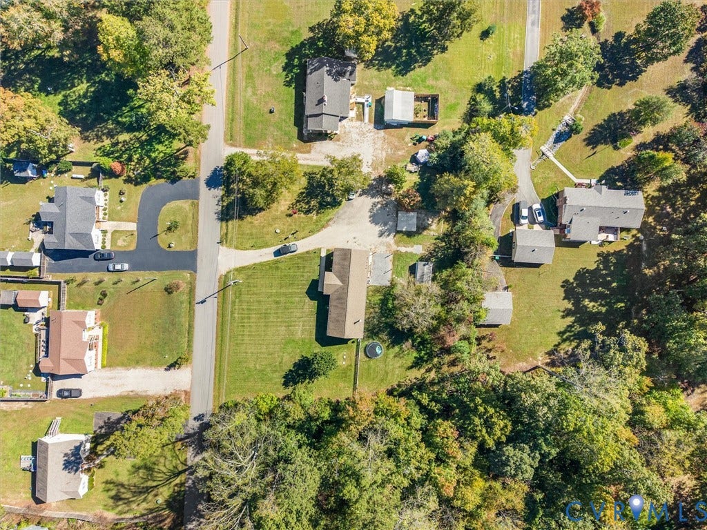 1625 Cedar Lane, Powhatan, VA 23139 Aerial perspective featuring a spacious lot with extensive tree canopy coverage, expansive manicured lawn, and paved driveway access