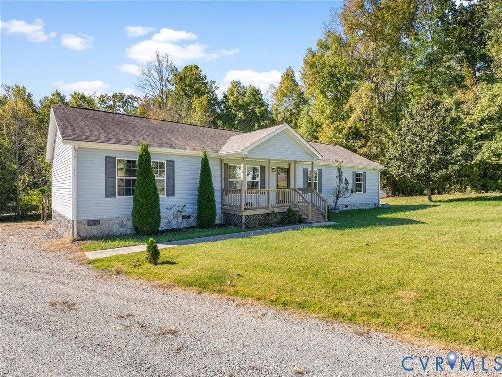 1625 Cedar Lane, Powhatan, VA 23139 Single-story residence featuring light blue siding, a stone-veneer foundation, a covered front porch with wooden railings, and a gravel driveway