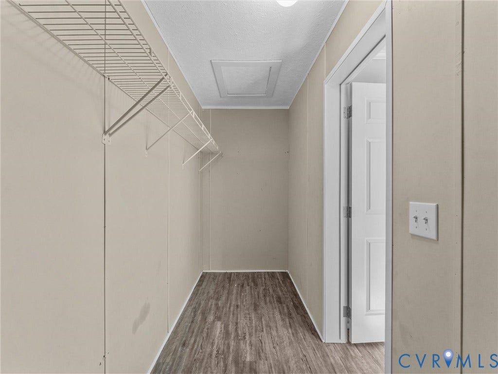 1625 Cedar Lane, Powhatan, VA 23139 Walk-in closet featuring wood-finish flooring, white paneled door, and wall-mounted wire shelving