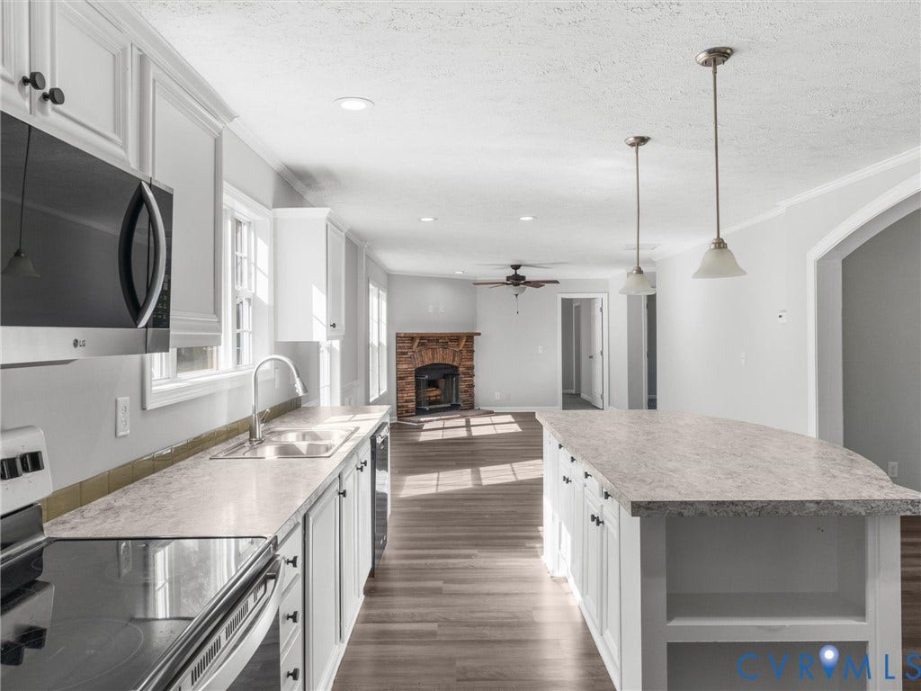 1625 Cedar Lane, Powhatan, VA 23139 Kitchen featuring white cabinetry, stone-patterned countertops, a central island with built-in shelving, stainless steel appliances, and wood-finish flooring