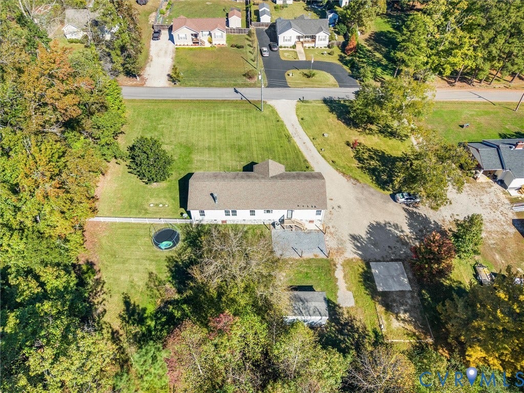 1625 Cedar Lane, Powhatan, VA 23139 Aerial perspective of a detached residence featuring an expansive lawn, a multi-vehicle driveway, an attached deck, and mature perimeter trees