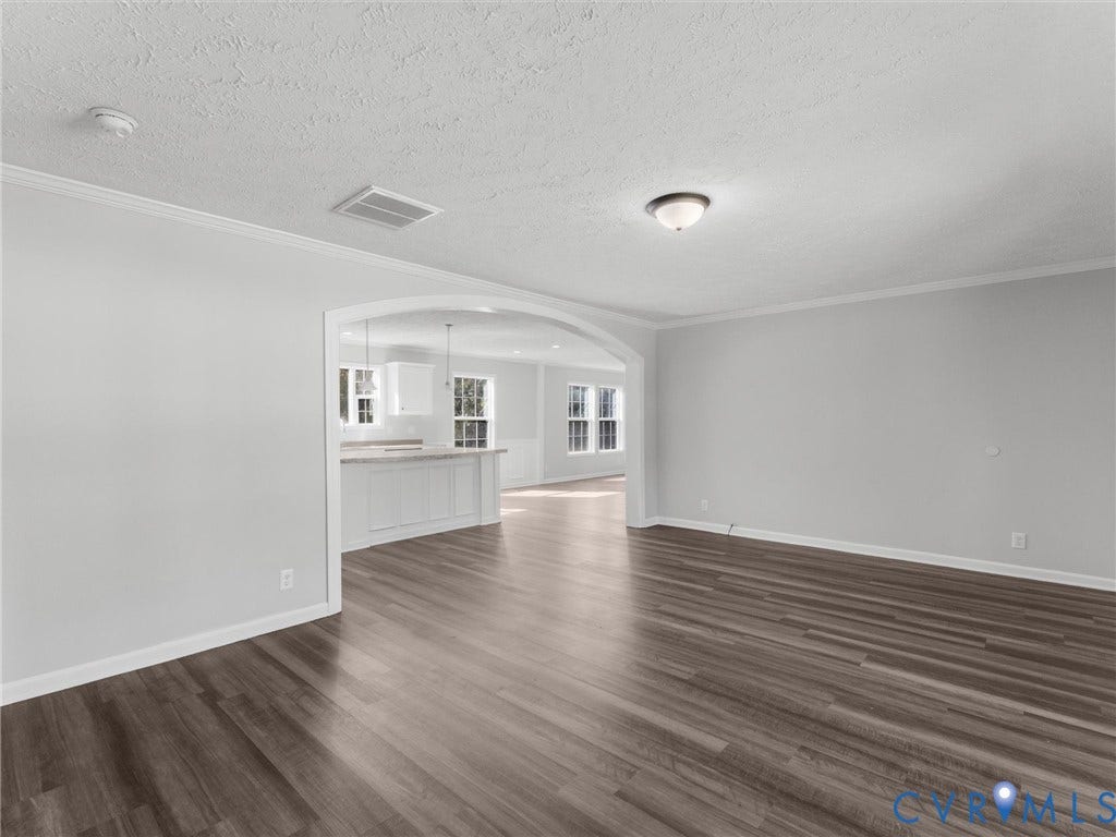 1625 Cedar Lane, Powhatan, VA 23139 Interior space featuring wood-finish flooring, neutral wall paint, a large arched opening, and crown molding