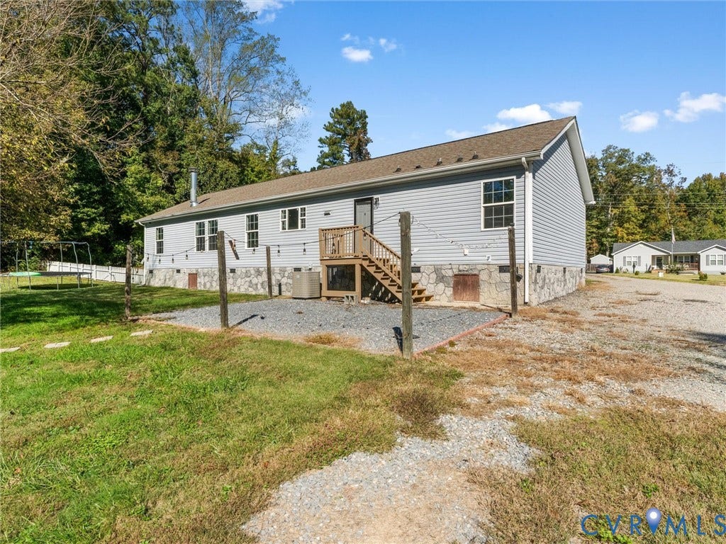 1625 Cedar Lane, Powhatan, VA 23139 Light gray horizontal siding, stone veneer foundation, shingled gable roof, and wood-framed staircase leading to the exterior entrance