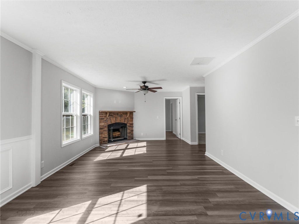 1625 Cedar Lane, Powhatan, VA 23139 Interior space featuring wood-finish flooring, a corner fireplace with a stone-style facade, wainscoting, and a ceiling fan