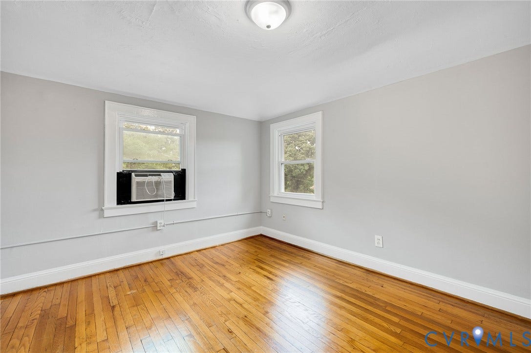 602 N 39th Street, Chimborazo, Richmond, VA 23223 Interior room featuring wood-finish flooring, neutral wall tones, two double-hung windows, and a flush-mount ceiling light fixture