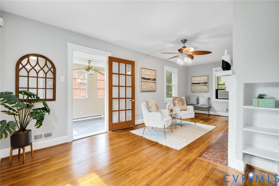 602 N 39th Street, Chimborazo, Richmond, VA 23223 Hardwood flooring, wood-framed French door, built-in shelving, painted brick fireplace hearth, and ceiling fan with integrated lighting