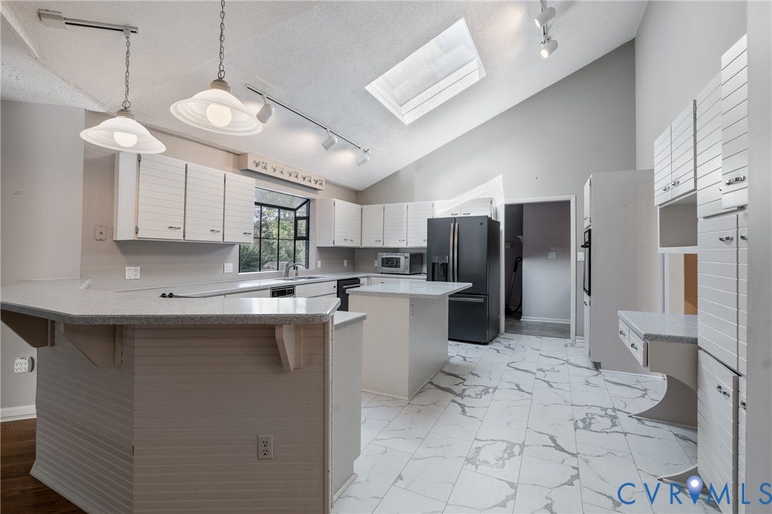 10862 Walton Lake Road, Dick Woods Subdivision, Disputanta, VA 23842 Kitchen featuring white paneled cabinetry, stone-finish countertops, a central island, a ceiling skylight, and track lighting
