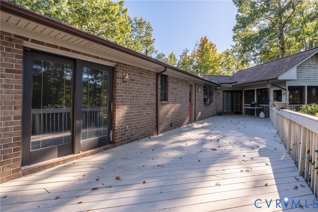10862 Walton Lake Road, Dick Woods Subdivision, Disputanta, VA 23842 Expansive wood-finish deck with perimeter railings, brick exterior, and sliding glass entry doors