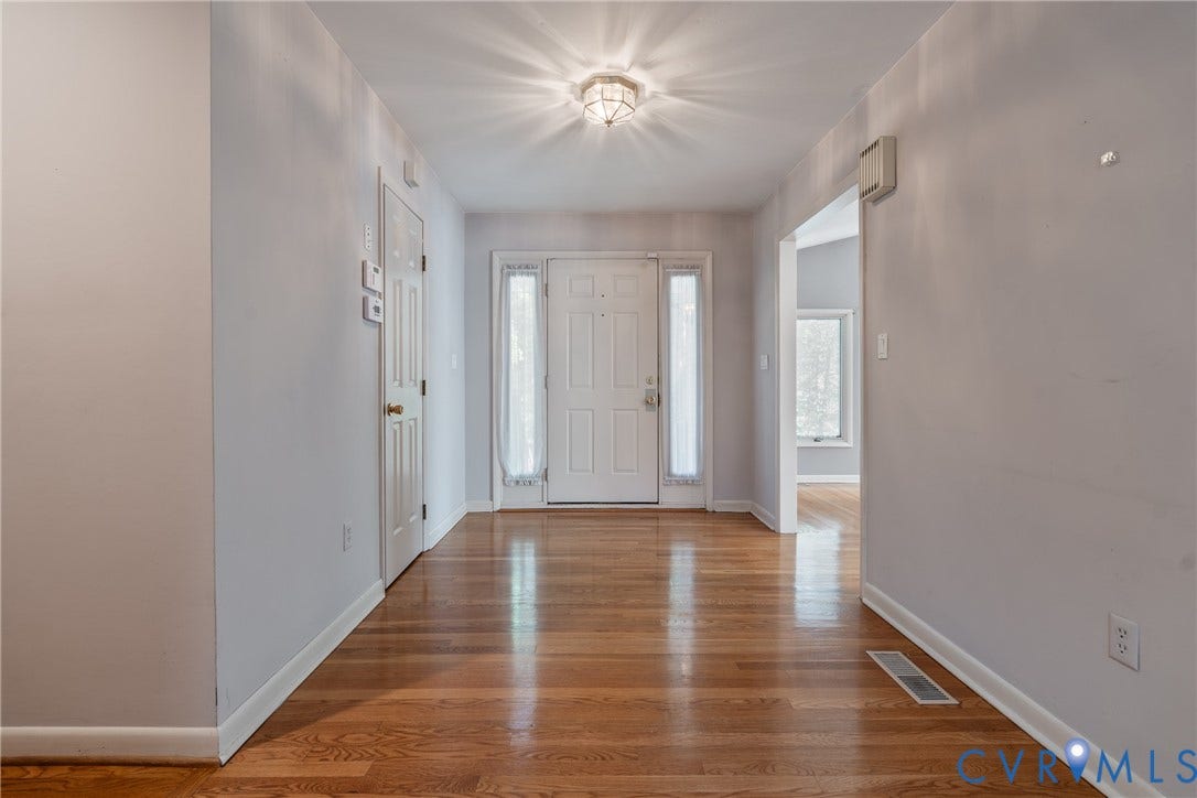 10862 Walton Lake Road, Dick Woods Subdivision, Disputanta, VA 23842 Entryway featuring wood-finish flooring, a paneled front door with sidelights, and a flush-mount ceiling light fixture