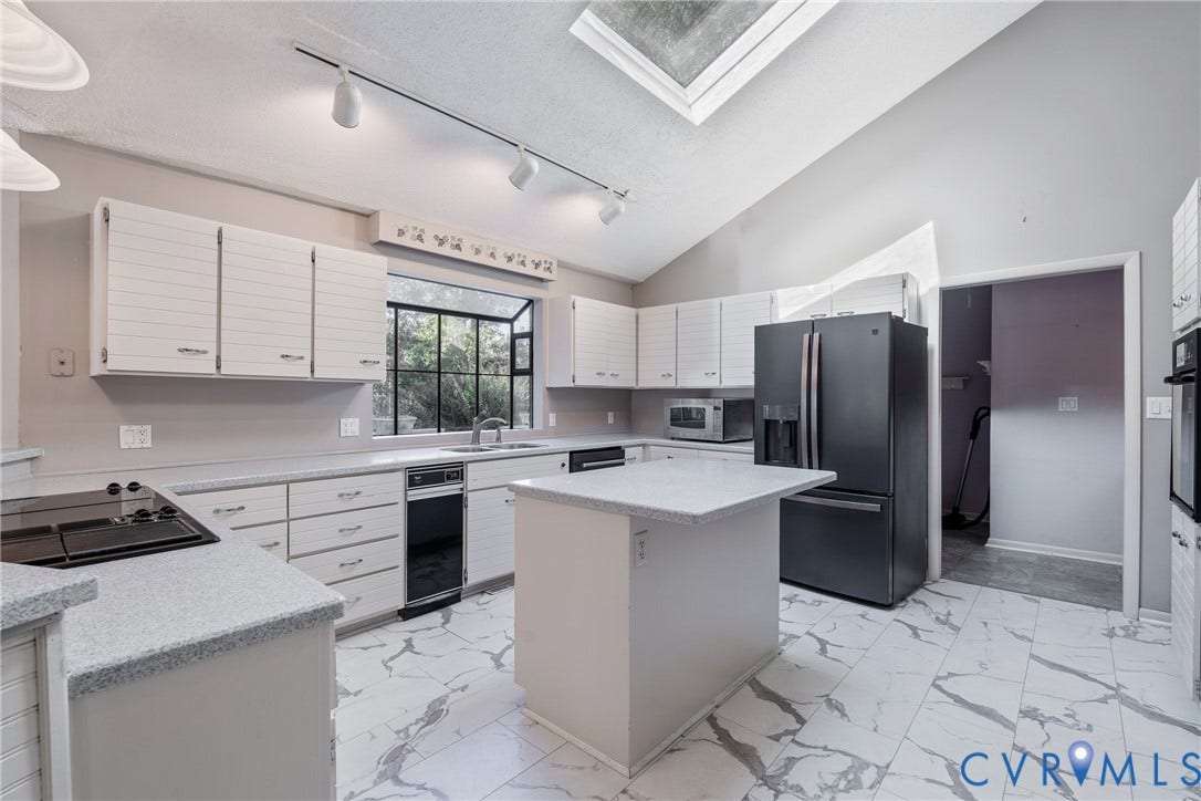10862 Walton Lake Road, Dick Woods Subdivision, Disputanta, VA 23842 Kitchen featuring vaulted ceilings, a skylight, stone-finish countertops, a central island, and tile flooring
