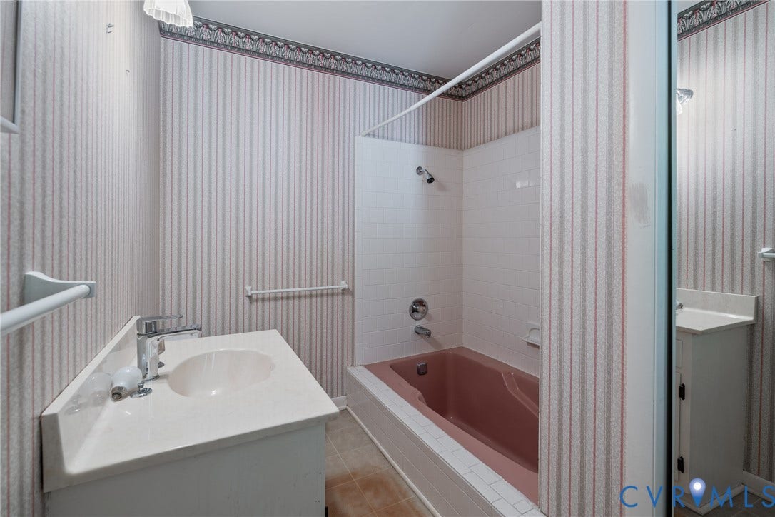 10862 Walton Lake Road, Dick Woods Subdivision, Disputanta, VA 23842 Full bathroom featuring a white vanity cabinet with an integrated sink, polished metal faucet, recessed bathtub with a tiled surround, and decorative wallpaper
