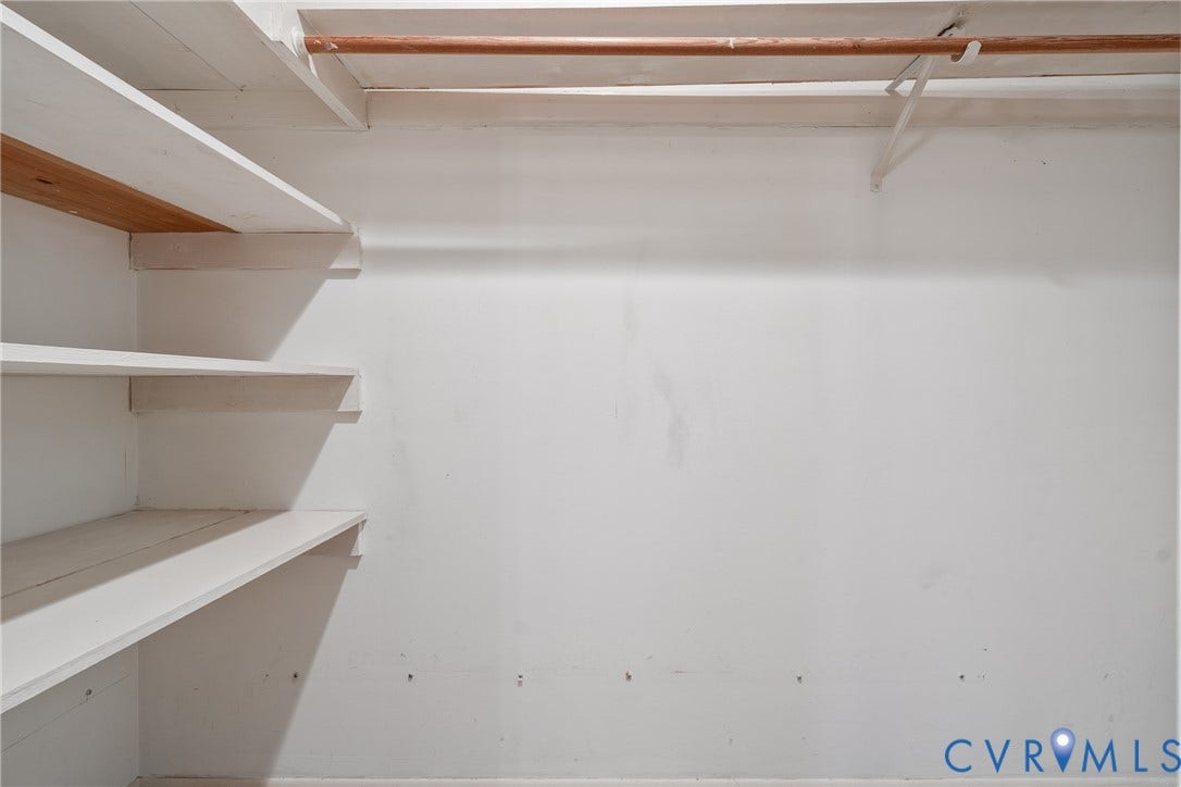 10862 Walton Lake Road, Dick Woods Subdivision, Disputanta, VA 23842 Storage area featuring white painted wooden shelving and a horizontal hanging rod