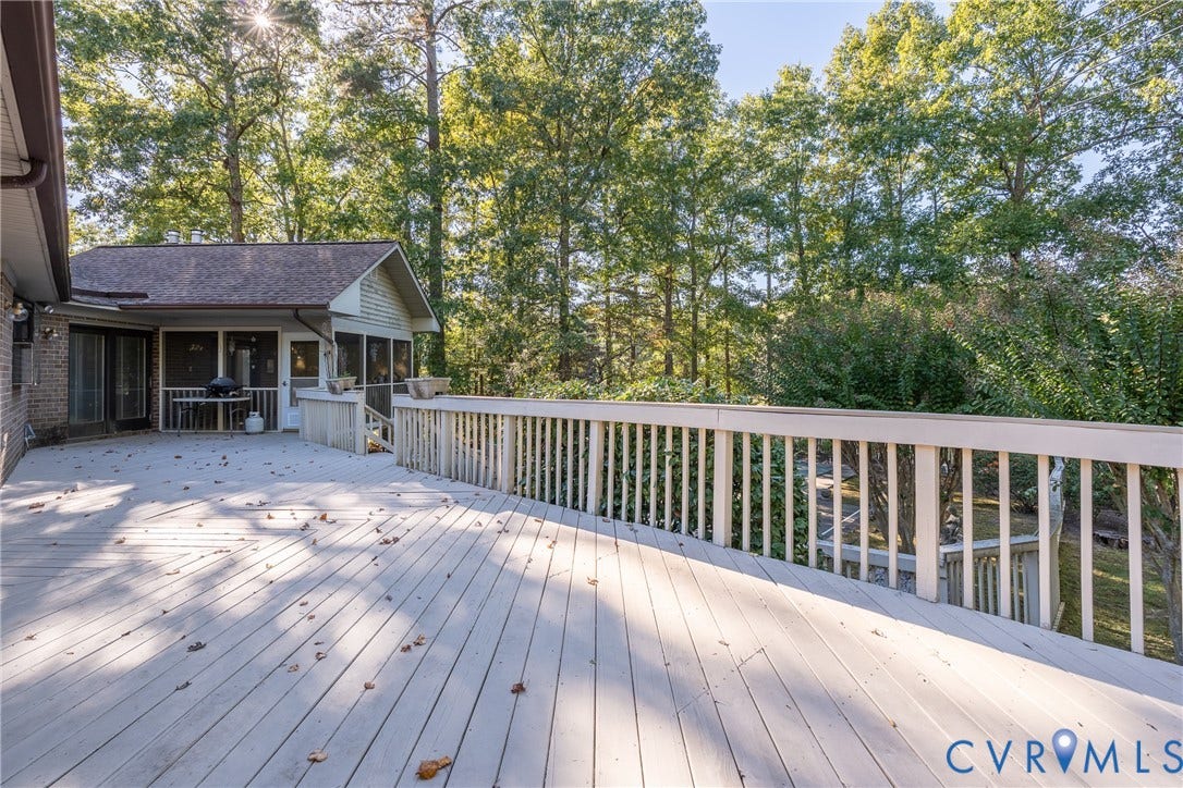 10862 Walton Lake Road, Dick Woods Subdivision, Disputanta, VA 23842 Expansive multi-level wood deck featuring painted railings and a covered screened-in porch with brick exterior detailing