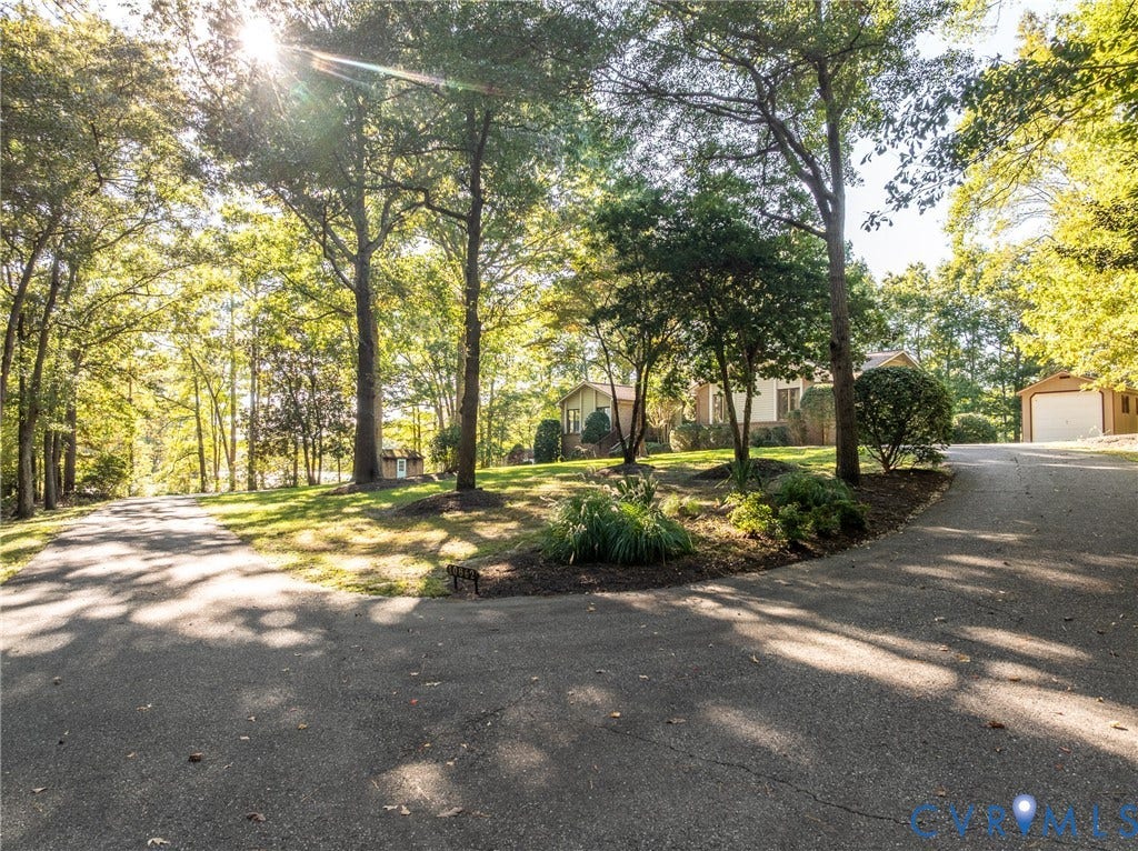 10862 Walton Lake Road, Dick Woods Subdivision, Disputanta, VA 23842 Asphalt driveway leading to a detached garage, expansive lawn, and mature canopy trees