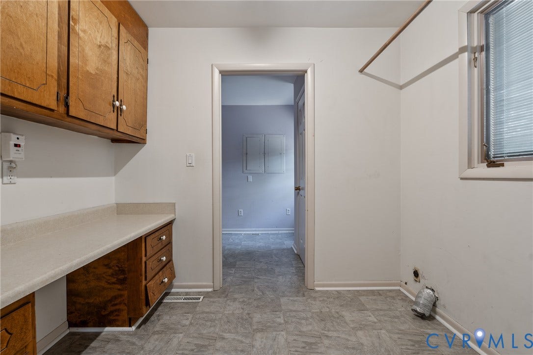 10862 Walton Lake Road, Dick Woods Subdivision, Disputanta, VA 23842 Utility area featuring wood cabinetry, laminate countertops with an integrated workspace, tile flooring, and a wall-mounted hanging rod