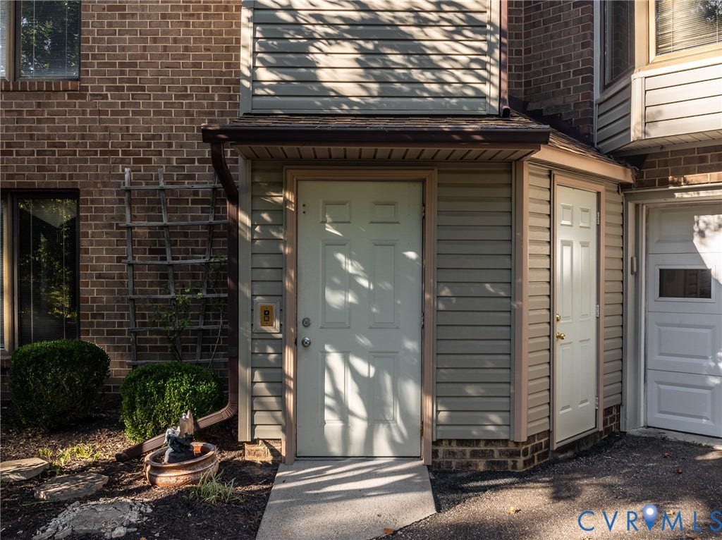 10862 Walton Lake Road, Dick Woods Subdivision, Disputanta, VA 23842 Multi-textured exterior featuring brick masonry and horizontal siding, covered entryway, and attached garage
