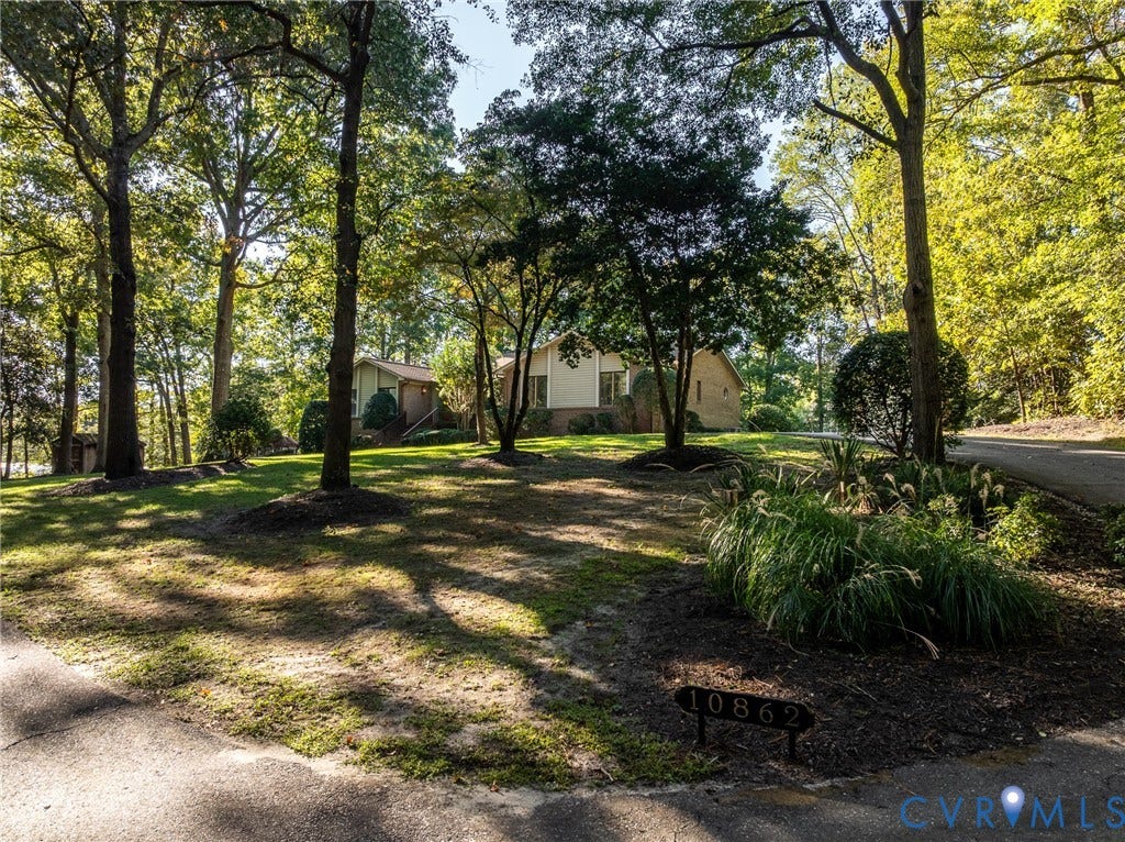 10862 Walton Lake Road, Dick Woods Subdivision, Disputanta, VA 23842 Expansive lot featuring mature trees, manicured landscaping, and an asphalt driveway