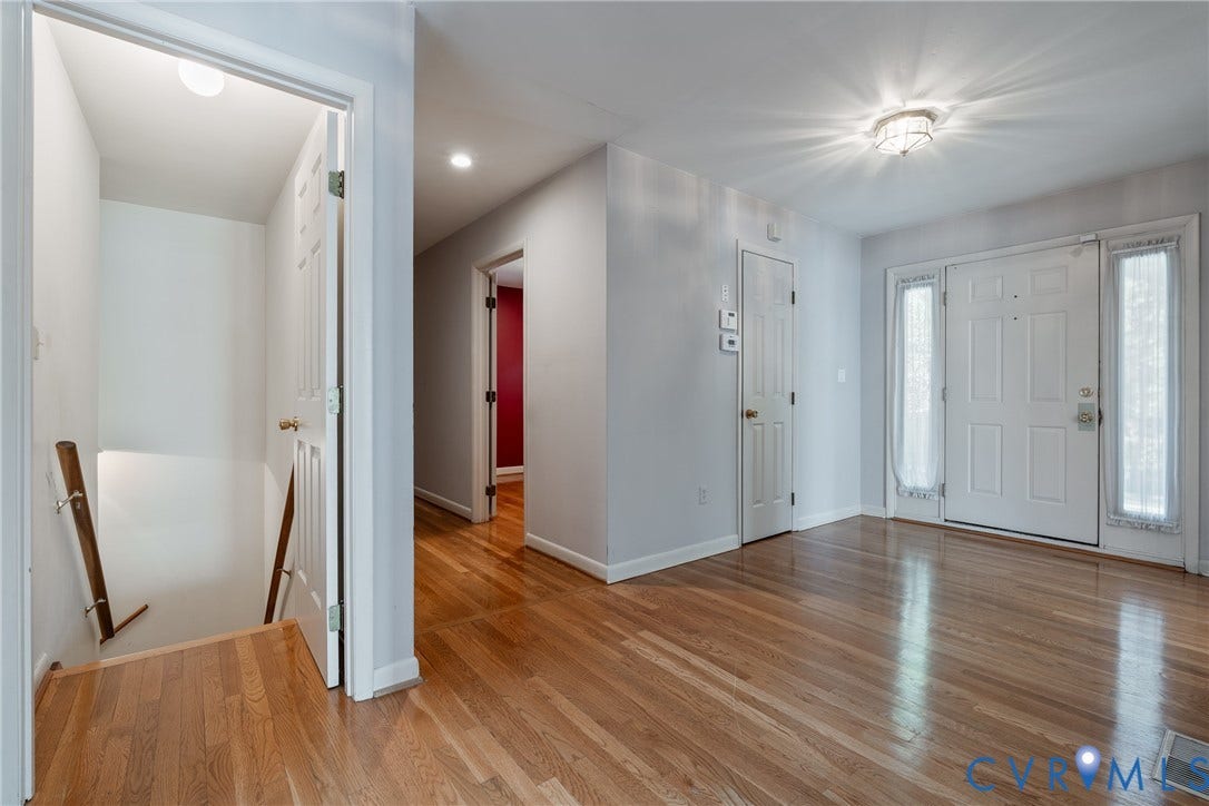 10862 Walton Lake Road, Dick Woods Subdivision, Disputanta, VA 23842 Entryway featuring wood-finish flooring, a paneled front door with flanking sidelights, flush-mount ceiling lighting, and a staircase with a wood handrail