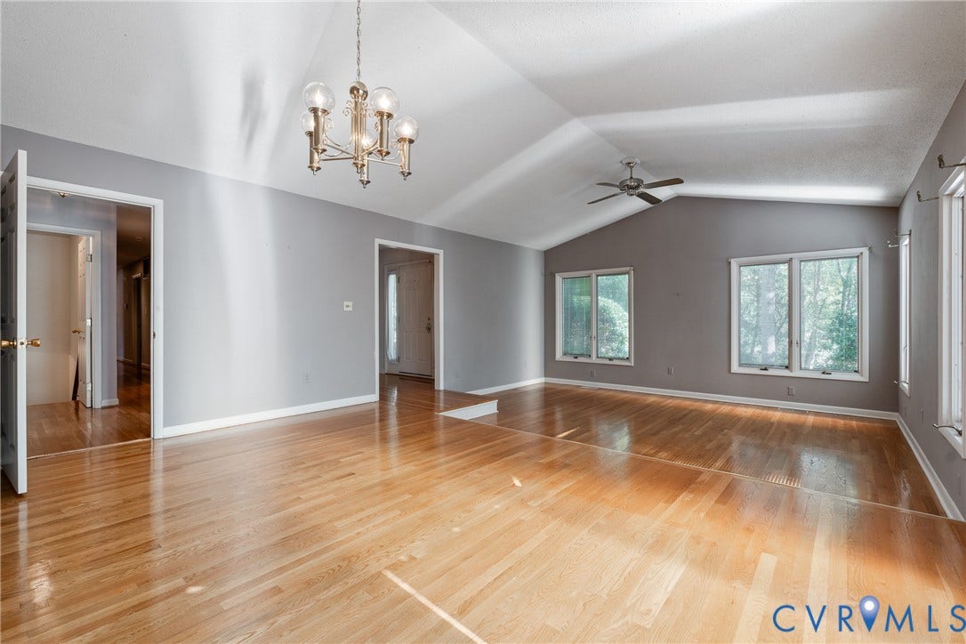 10862 Walton Lake Road, Dick Woods Subdivision, Disputanta, VA 23842 Vaulted ceilings with a five-light chandelier, wood-finish flooring, and multiple dual-pane windows