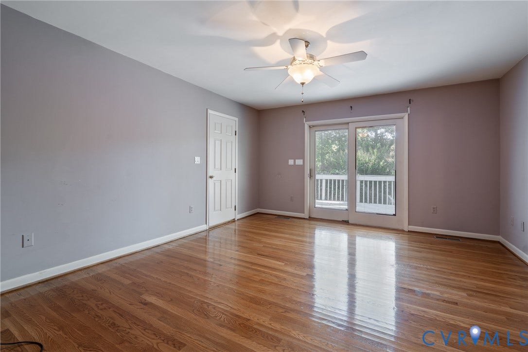 10862 Walton Lake Road, Dick Woods Subdivision, Disputanta, VA 23842 Room featuring wood-finish flooring, a ceiling fan with integrated lighting, a six-panel interior door, and sliding glass doors opening to an exterior deck