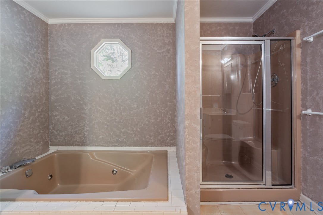 10862 Walton Lake Road, Dick Woods Subdivision, Disputanta, VA 23842 Built-in jetted soaking tub with tile surround, standalone shower with glass enclosure, and octagonal window