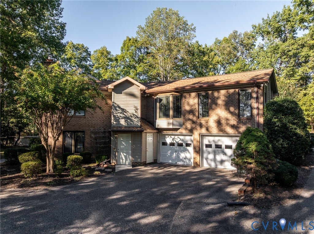 10862 Walton Lake Road, Dick Woods Subdivision, Disputanta, VA 23842 Two-story brick exterior featuring a multi-car garage, asphalt driveway, bay window, and gabled roofline
