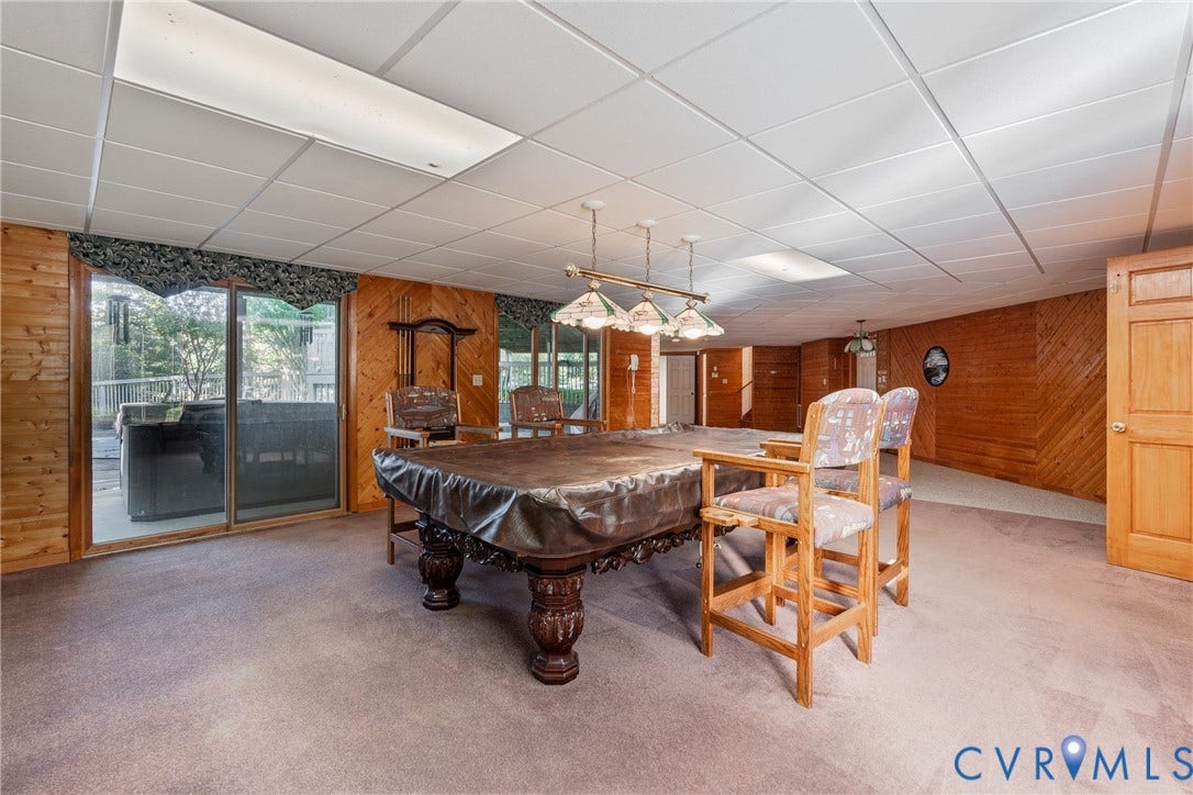 10862 Walton Lake Road, Dick Woods Subdivision, Disputanta, VA 23842 Wood-paneled walls, sliding glass door, multi-light pendant fixture, drop ceiling, and carpeting