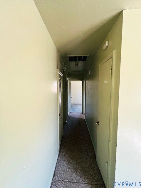 1525 Circle Drive, Petersburg, VA 23803 Hallway featuring neutral-toned wall paint, carpeted flooring, multiple interior doors, and overhead lighting