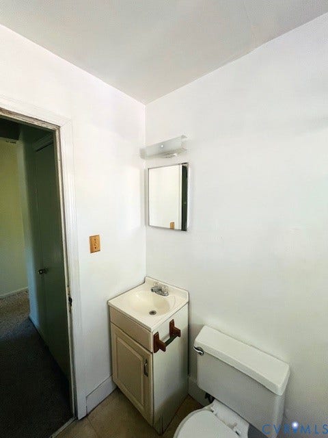 1525 Circle Drive, Petersburg, VA 23803 Compact vanity featuring a rectangular basin, integrated storage cabinet, wall-mounted mirror, and polished metal light fixture
