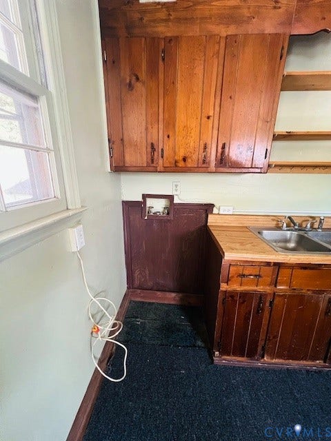 1525 Circle Drive, Petersburg, VA 23803 Custom wood cabinetry, dual-basin stainless steel sink, solid wood-surface countertop, and open wall shelving