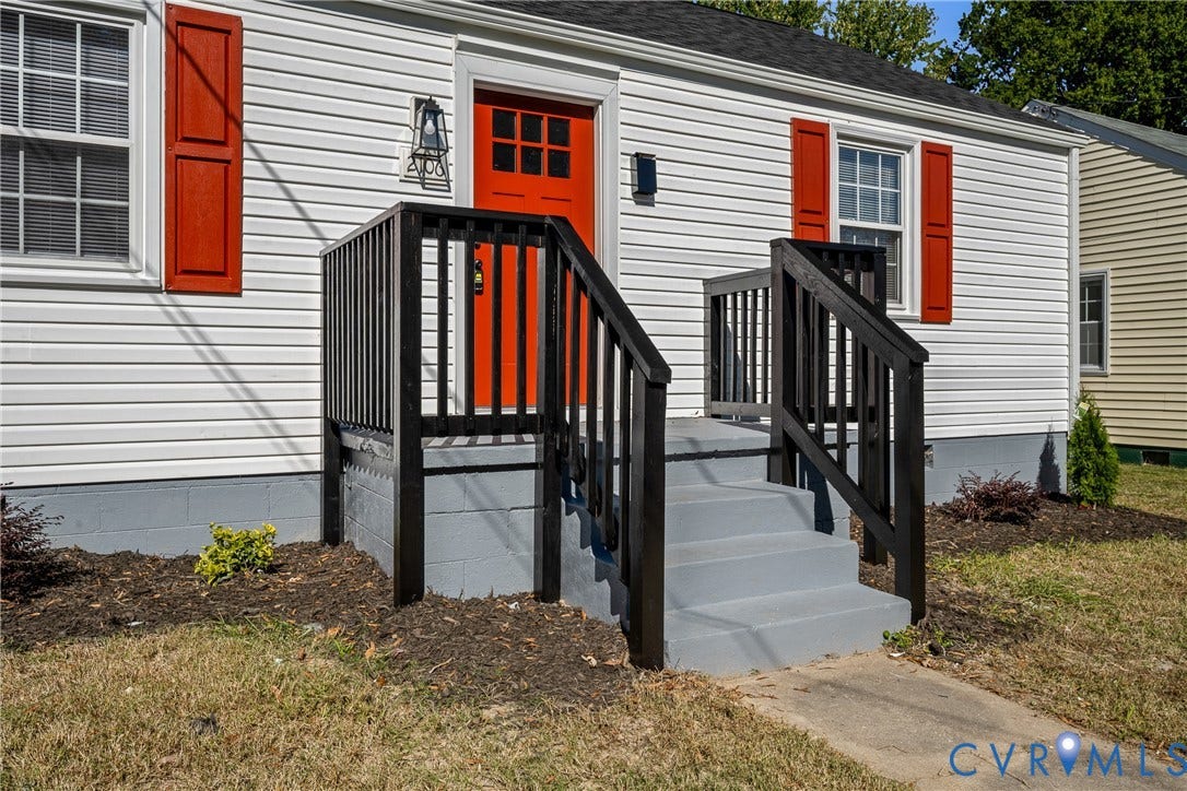 2106 Kenwood Avenue, Henrico, VA 22229 Exterior featuring white horizontal siding, contrasting red shutters, a dedicated front entry with a raised porch, black wooden railing, and a painted concrete staircase