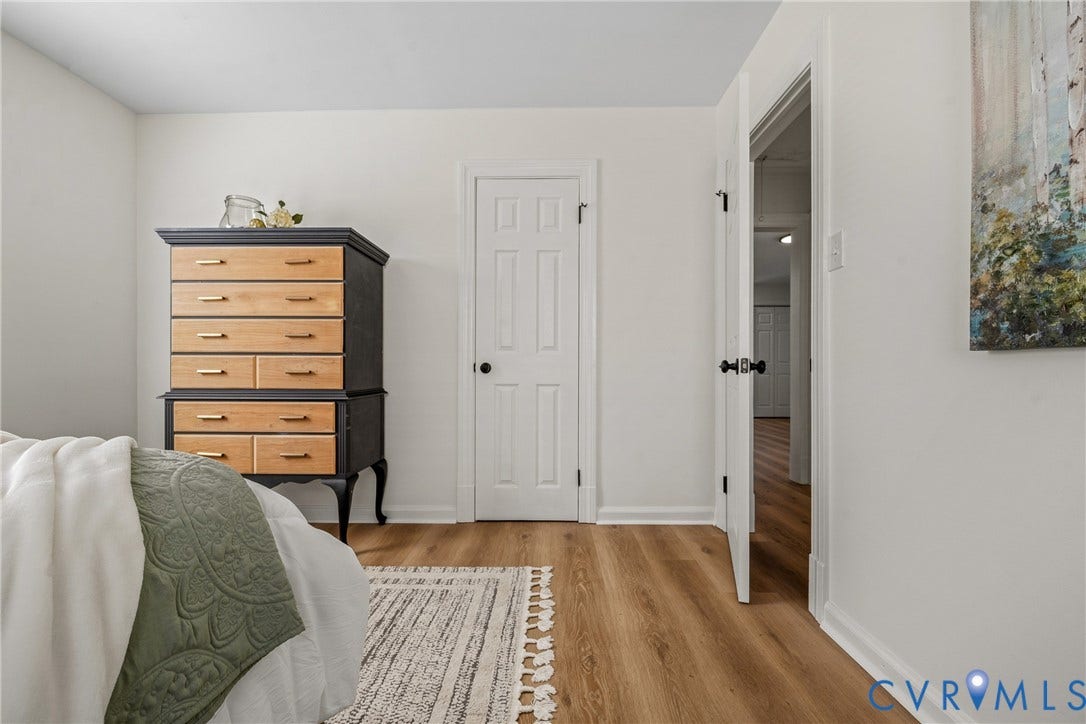 2106 Kenwood Avenue, Henrico, VA 22229 Neutral-toned interior room featuring wood-finish flooring, white walls, and a six-panel door with matte black hardware