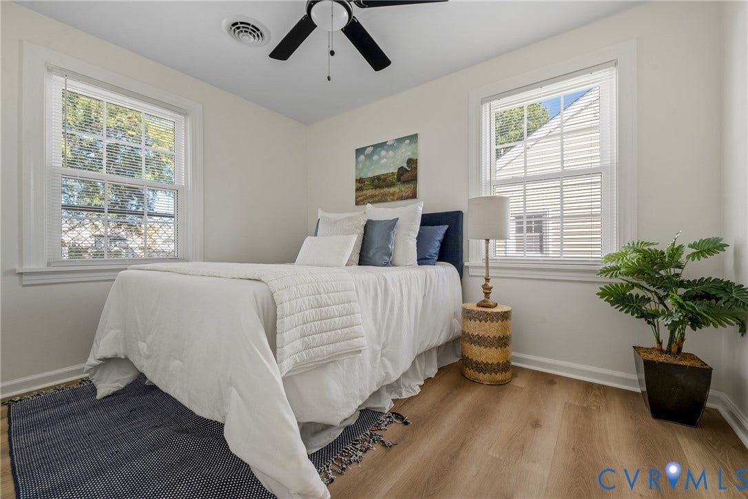 2106 Kenwood Avenue, Henrico, VA 22229 Neutral-toned interior room featuring wood-finish flooring, dual windows with grid detailing, and a ceiling-mounted fan with integrated lighting