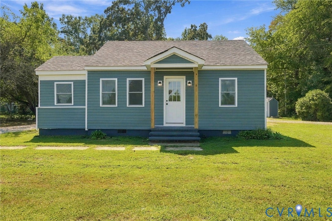 Single-story residence featuring blue horizontal siding, a gabled covered entryway with wooden support posts, and multi-pane windows