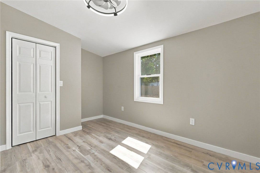 Neutral-toned walls, wood-finish flooring, double-panel closet doors, single-hung window, and a ceiling-mounted light fixture