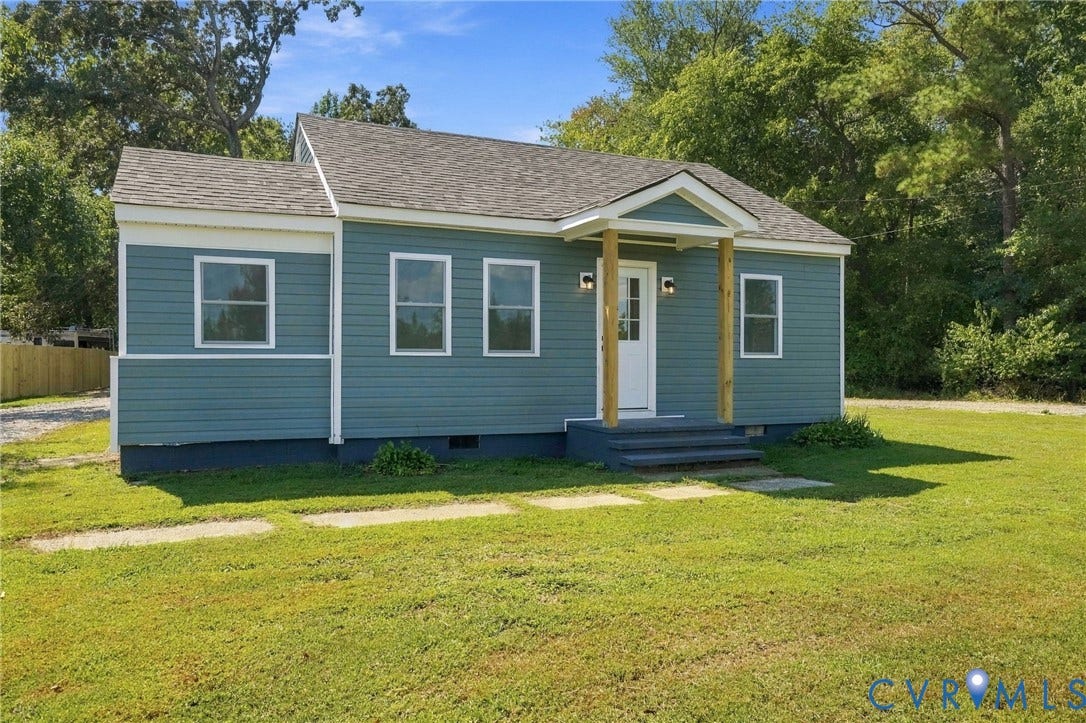 Single-story residence featuring blue horizontal siding, a covered front entryway with wood support posts, and asphalt shingle roofing