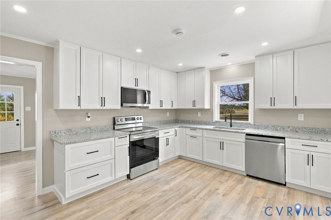 Kitchen featuring white shaker-style cabinetry, speckled stone countertops, stainless steel appliances, recessed ceiling lighting, and wood-finish flooring