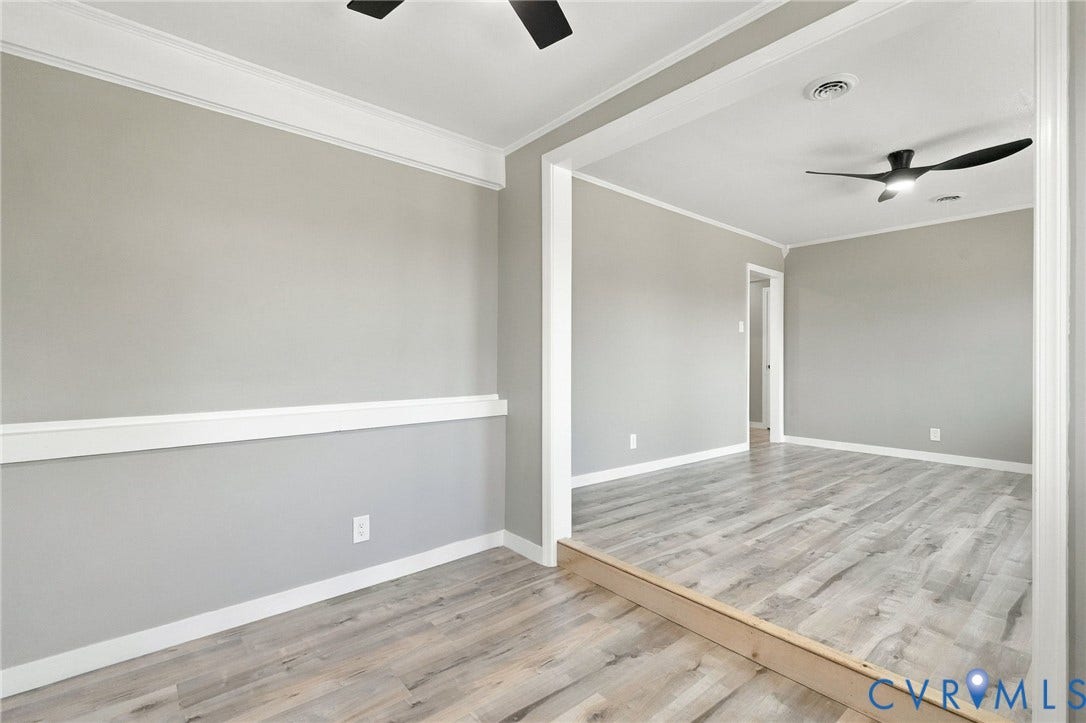 Interior featuring wood-finish flooring, crisp crown molding, chair rail trim, and multi-blade ceiling fans