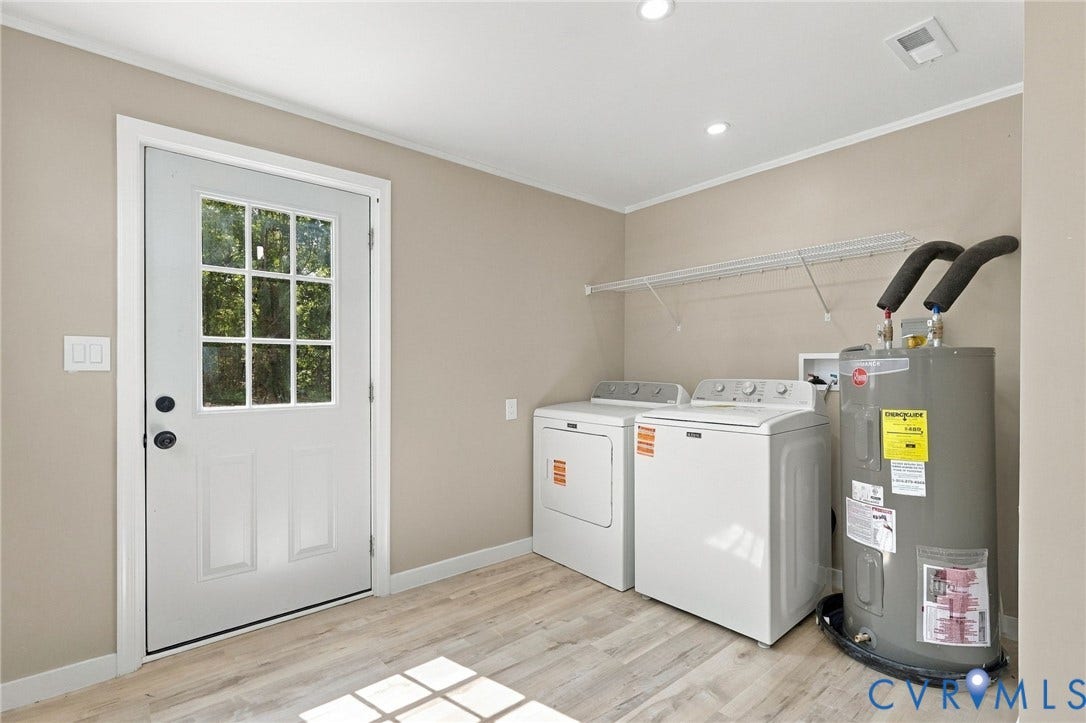 Utility room featuring wood-finish flooring, a multi-pane glass door, and built-in wire shelving