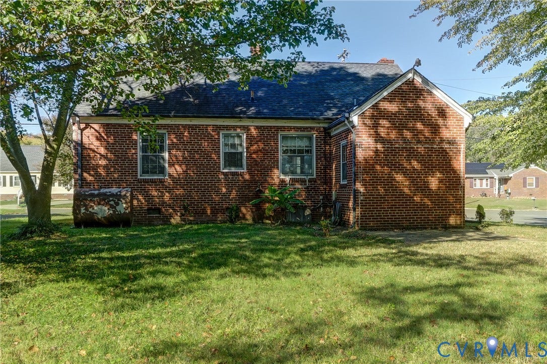 4007 Austin Avenue, Richmond, VA 23222 Exterior red brick facade featuring a dark shingle roof, multi-pane windows, and a mature tree-lined lot