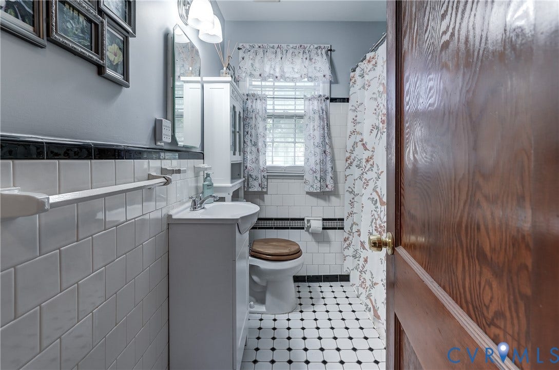 4007 Austin Avenue, Richmond, VA 23222 Bathroom featuring white subway wall tile with black decorative trim, pedestal sink, and black-and-white hex tile flooring