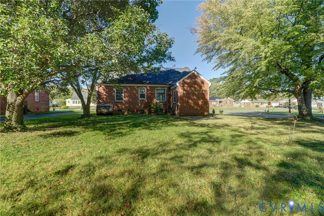 4007 Austin Avenue, Richmond, VA 23222 Brick exterior featuring a multi-gabled roofline and mature hardwood trees on the grounds