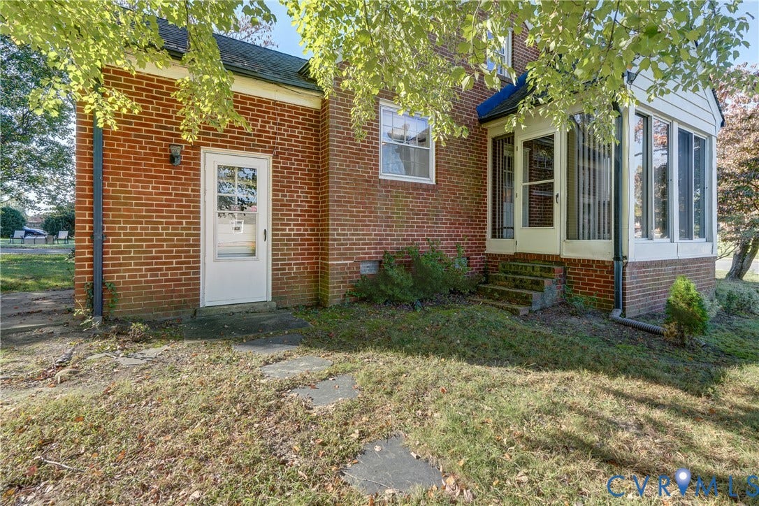 4007 Austin Avenue, Richmond, VA 23222 Exterior brick facade featuring a sunroom with vertical windows, a secondary entry door, and stone paver walkway