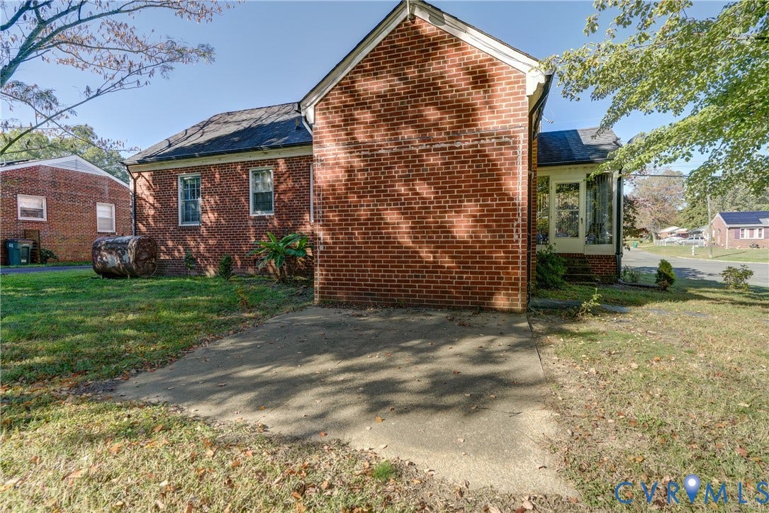 4007 Austin Avenue, Richmond, VA 23222 Brick exterior with a concrete patio, multi-pane windows, and a glass-paneled entry door