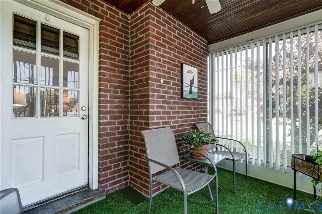 4007 Austin Avenue, Richmond, VA 23222 Enclosed porch featuring exposed brick wall, nine-lite glass panel door, wood-paneled ceiling, and vertical window blinds