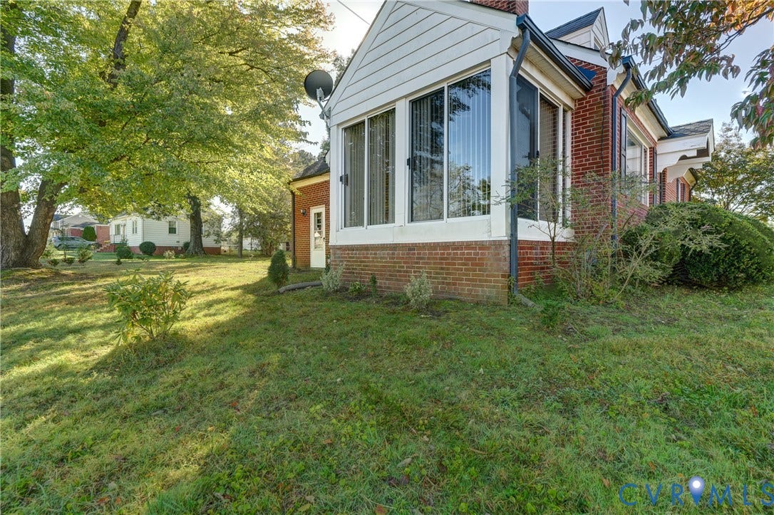 4007 Austin Avenue, Richmond, VA 23222 Brick and white siding exterior featuring a multi-windowed sunroom and mature landscaping