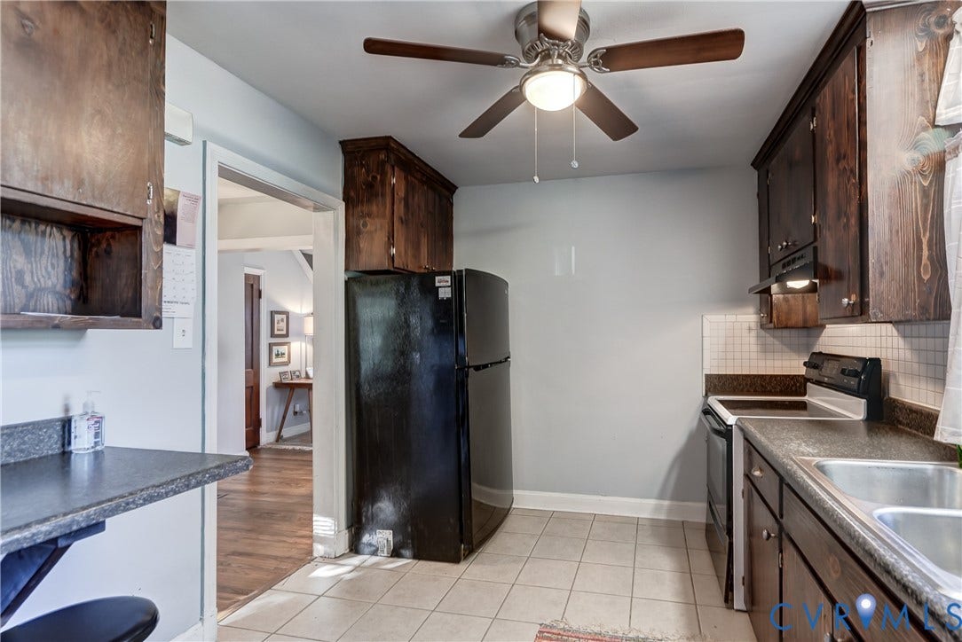 4007 Austin Avenue, Richmond, VA 23222 Kitchen featuring dark wood-finish cabinetry, a black refrigerator, a double-basin stainless steel sink, tiled backsplash, and a ceiling fan