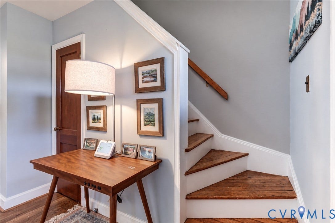 4007 Austin Avenue, Richmond, VA 23222 Staircase featuring wood-finish treads, white risers, and a mounted wooden handrail, paired with a solid wood panel interior door