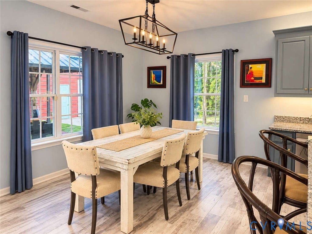 5424 Bellswood Drive, Mechanicsville, VA 23111 Dining space featuring wood-finish flooring, a geometric metal chandelier, multi-pane windows, and light-toned cabinetry with stone-finish countertops